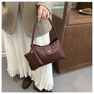 Detail of burgundy woven hobo bag with matching mini pouch and leather strap texture