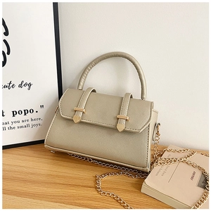 Vue détaillée du mini sac à main or champagne avec texture Saffiano et bandoulière chaîne