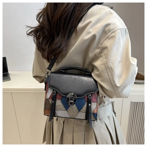 Macro detail of retro patchwork leather handbag featuring contrast colors and metal turn-lock