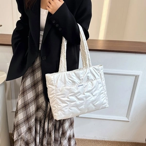 Détail du sac cabas matelassé blanc avec motif de losanges brodés et étiquette tendance