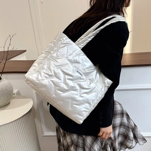 Détail d'un sac cabas rembourré blanc avec finition brillante et étiquette de mode