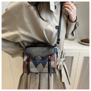 Close-up of geometric patchwork crossbody bag with metallic buckle and color blocking
