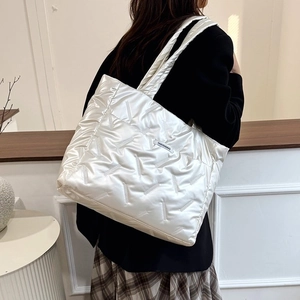Gros plan d'un sac cabas rembourré blanc avec coutures géométriques et étiquette mode