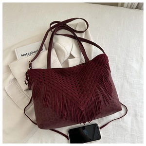 Dettaglio borsa tote bordeaux con frange, stampa leopardata e texture in pelle