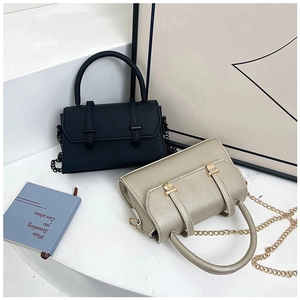 Détail de mini sacs à main en noir et or champagne avec bandoulières en chaîne