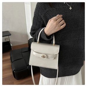 Chic cream small square handbag featuring a gold metallic twist lock and elegant top handle