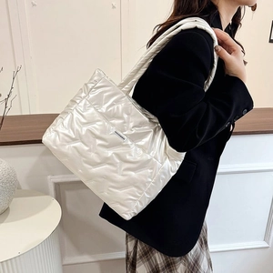 Détail de la texture matelassée en V et de l'étiquette sur le grand sac cabas blanc