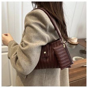 Detail of burgundy woven hobo bag with gold snap button and matching small pouch