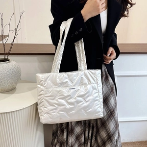 Détail du grand sac cabas blanc brillant matelassé avec broderie et texture douce