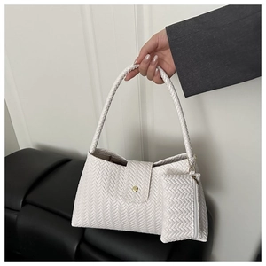 Detail of white woven underarm bag with matching mini pouch and gold buckle closure