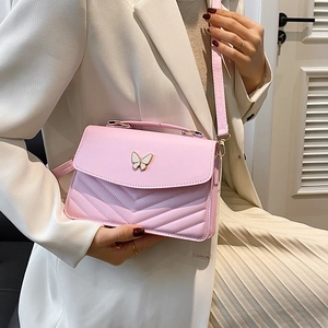 Sac bandoulière rose matelassé avec ornement papillon et poignée élégante en cuir