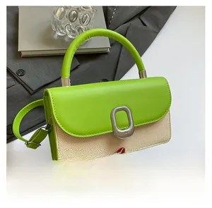 Détail du cuir vert et de la paille tressée beige avec un fermoir en métal argenté