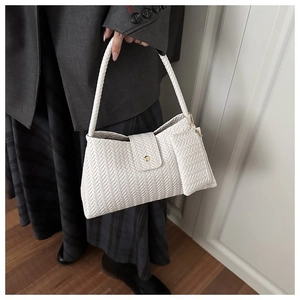 Detail of white woven underarm bag featuring chevron texture and matching coin purse