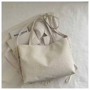 Dettaglio borsa tote color crema con sottile motivo leopardato e doppie tracolle