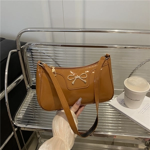 Caramel patent leather baguette bag with golden bow and elegant French vintage finish