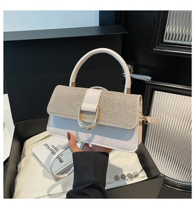 Detail of white leather crossbody bag with sparkling flap and golden D-shaped clasp