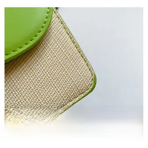 Détail du rabat en cuir vert et du tissage en paille sur le petit sac à bandoulière