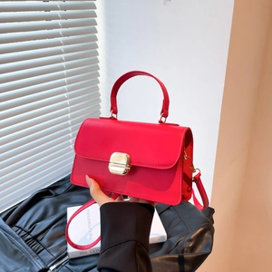 Classic red minimalist handbag with golden square twist lock shown in hand for daily wear