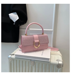 Close-up of pink glitter patchwork handbag with gold D-buckle and elegant handle