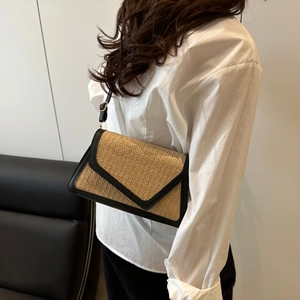 Minimalist straw woven square crossbody bag with black trim and envelope flap on model
