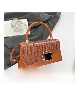 Detailed shot of the brown stone pattern handbag with its signature gold clasp and hardware