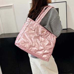 Vue détaillée du sac cabas matelassé rose avec fini satiné et bandoulière rembourrée