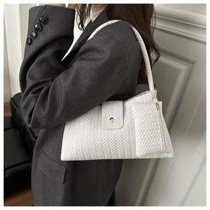 Detail of white woven underarm bag featuring a small coin purse and magnetic clasp