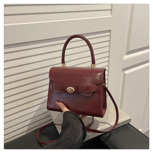 Elegant burgundy leather crossbody box bag with gold swivel lock and top handle