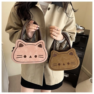 Detail of cute cat-shaped plush shoulder bags in pink and brown with embroidery