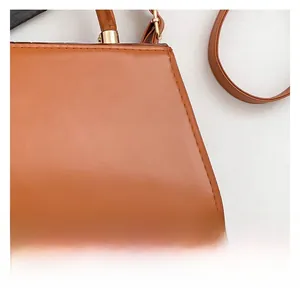 Close-up of caramel brown stone pattern faux leather handbag with golden metal hardware