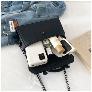 Vue intérieure d'un sac en cuir noir mat montrant la capacité pour lunettes et cosmétiques