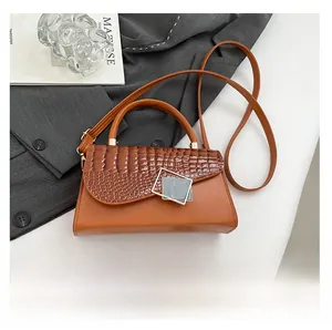 Detailed view of brown crocodile texture bag next to a phone for size comparison