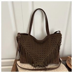 Dettaglio ravvicinato della borsa tote marrone scuro con frange a V e nappe boho chic