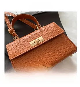Gros plan détaillé sur le sac à texture croco marron avec fermoir doré et poignée