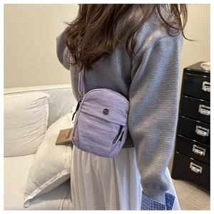 Lavender nylon crossbody bag with metal logo detail and lightweight wrinkled texture