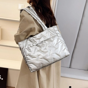 Détail du sac cabas matelassé argenté avec finition métallisée et étiquette tissée