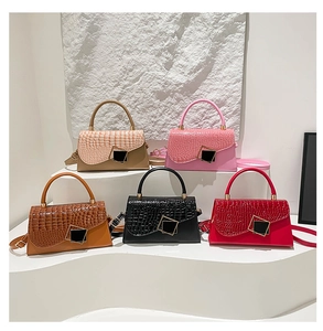 Five stylish crocodile pattern flap crossbody bags in various colors on white stone steps