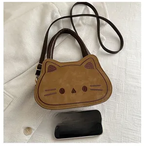 Detailed size comparison of a brown cat crossbody bag with a mobile phone on fabric