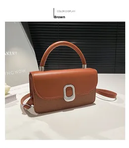 Détail du sac à bandoulière en cuir marron et texture tissée avec boucle et poignée épaisse