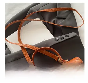 Détails de la texture en cuir tissé orange et des ferrures métalliques sur le sac à main
