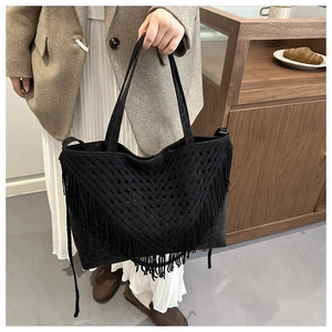 Dettaglio della borsa shopper nera con stampa leopardata e frange boho in stile crochet