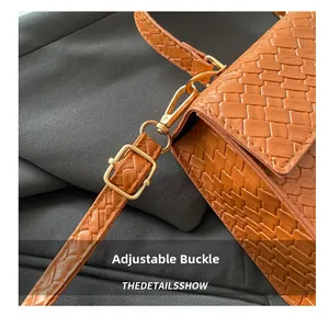 Détail de la boucle en métal doré et bandoulière réglable sur sac à main marron croco