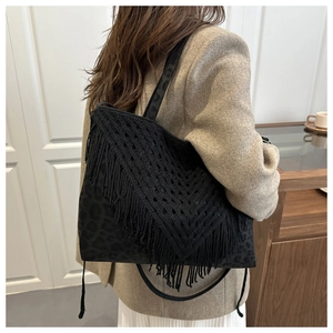 Dettaglio della borsa leopardata nera con motivo a V all'uncinetto e frange boho