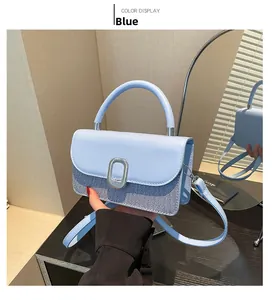 Détail du sac bleu contrasté avec textures en cuir et denim et fermoir métallique ovale