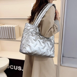 Détail du sac fourre-tout argenté matelassé avec fini métallisé et bandoulière rembourrée