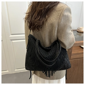 Dettaglio borsa tote nera leopardata con lunghe nappe a frange e finitura opaca morbida