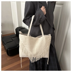 Dettaglio della borsa tote crema con frange in macramè fatte a mano e design minimalista