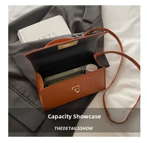 Vue intérieure montrant la capacité du sac à main effet crocodile avec accessoires