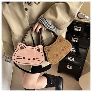 Detailed embroidery of cat face on pink and camel faux suede crossbody bags