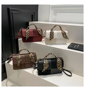 Detail view of stylish square handbags in four colors featuring leopard silk scarf handles